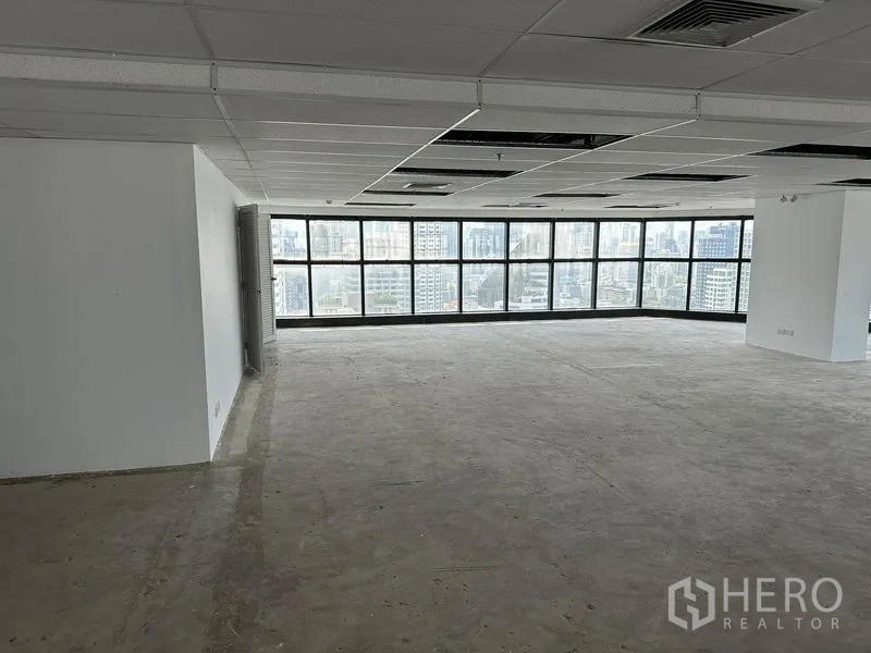 办公空间 出租 - 宽敞矩形办公区，大幅窗户、中央立柱与空调出风口。