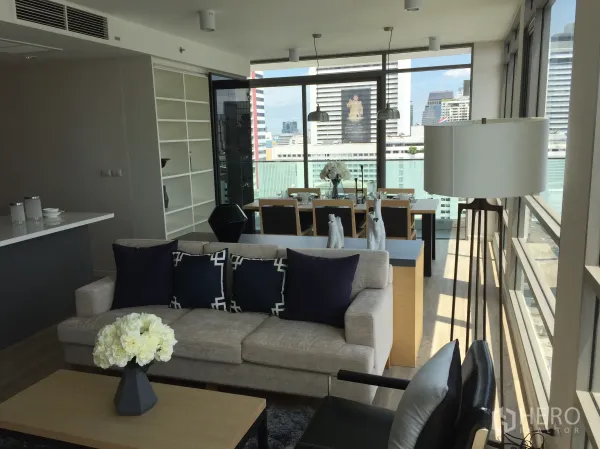 Condominium for sale in Bang Rak, Bangkok - Bright open-plan living and dining area with floor-to-ceiling windows and city skyline views in a modern Bangkok condo.