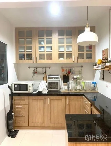 ทาวน์เฮาส์ ให้เช่าในSuan Luang, Bangkok - ครัวบิวท์อินขนาดกะทัดรัด ตู้ไม้ ท็อปหินแกรนิต และโคมไฟห้อย