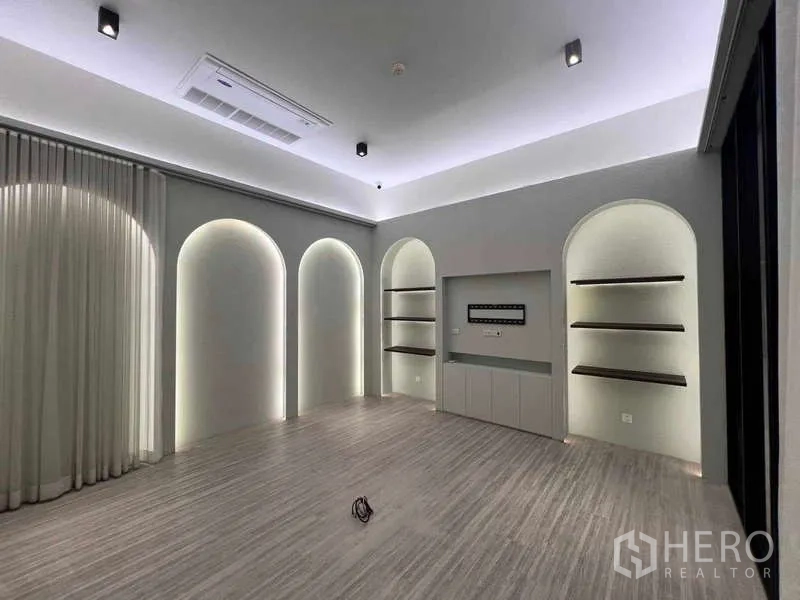 Retail Space for rent - Showroom area with arched alcove displays, soft backlighting, ceiling air-conditioning, and light wood floors.