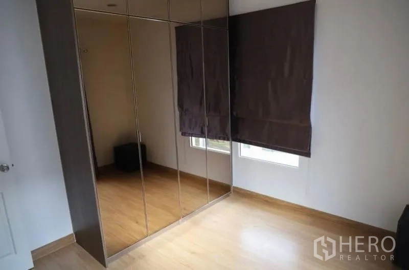 Detached House for rent in Suan Luang, Bangkok - Second bedroom with mirrored wardrobes and two corner windows.