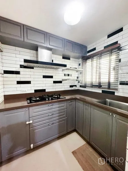 ทาวน์เฮาส์ ให้เช่าในPhra Khanong, Bangkok - ครัวรูปตัว U สีเทา ผนังกระเบื้องซับเวย์ พร้อมเตาแก๊ส