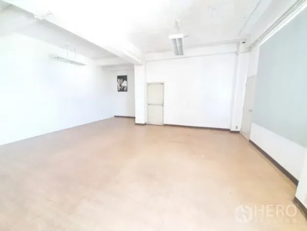 Office Space for rent in Bang Na, Bangkok - Spacious white office room with high ceiling, fluorescent fixtures and a single door, ready for fit-out.