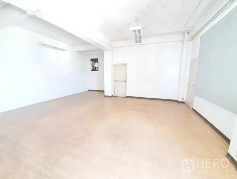 Office Space for rent in Bang Na, Bangkok - Spacious white office room with high ceiling, fluorescent fixtures and a single door, ready for fit-out.