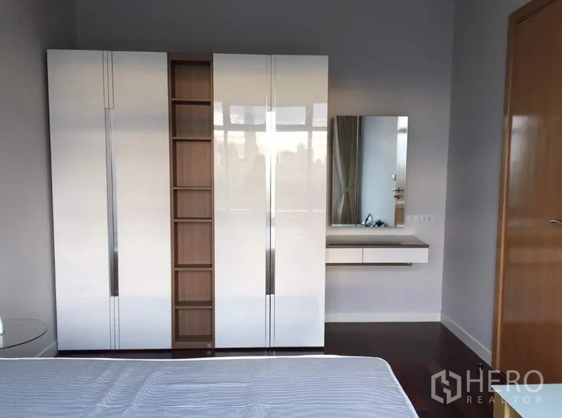 公寓 出租或出售在Ratchathewi, Bangkok - 主卧设亮白衣柜、开放格架及悬挂式梳妆台与镜子。