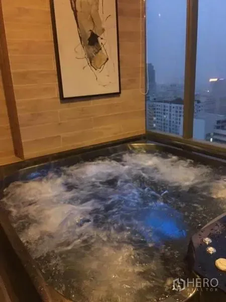 公寓 出租在Watthana, Bangkok - 室内漩涡按摩池，临落地窗可观城市景观。