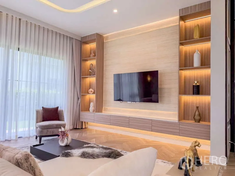 Detached House for rent or sale in Bang Kapi, Bangkok - Custom TV wall with illuminated shelving and full-height curtains.