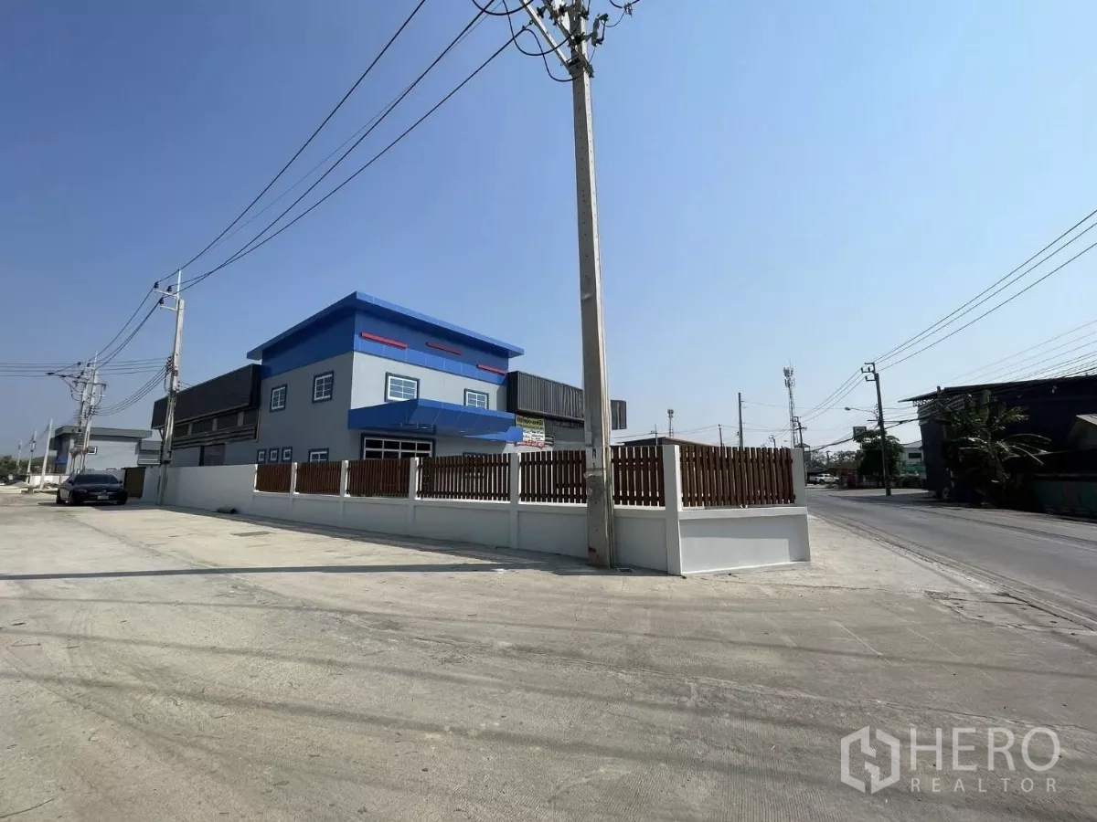 工厂 出租或出售在Bang Phli, Samut Prakan - 建筑转角外观，围墙与木栅栏，直接临主干道出入口。