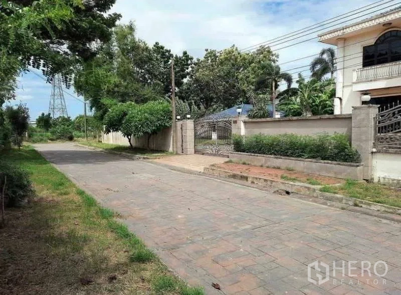 独立式住宅 出售在Prawet, Bangkok - 住宅前的铁门与宽阔车道