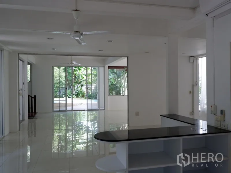 Detached House for rent in Khlong Toei, Bangkok - Spacious living and dining zone with sliding glass doors opening to the pool.