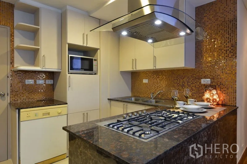 คอนโด ให้เช่าในWatthana, Bangkok - มุมครัวที่มีไมโครเวฟบิวท์อิน เครื่องล้างจาน ตู้สีขาวจำนวนมาก และท็อปหิน