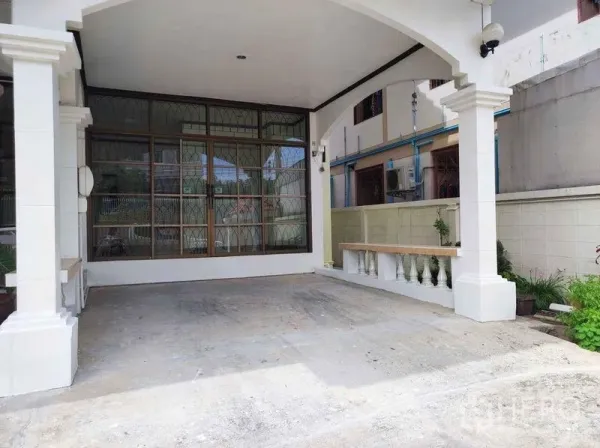 Detached House for rent in Khlong Toei, Bangkok - Covered carport with arches and pillars beside a large windowed wall, providing shaded parking.