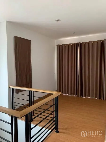 บ้าน ขายในSuan Luang, Bangkok - โถงชั้นบนพื้นไม้ ใช้เป็นมุมนั่งเล่น พร้อมผ้าม่านทึบสูงจรดพื้น