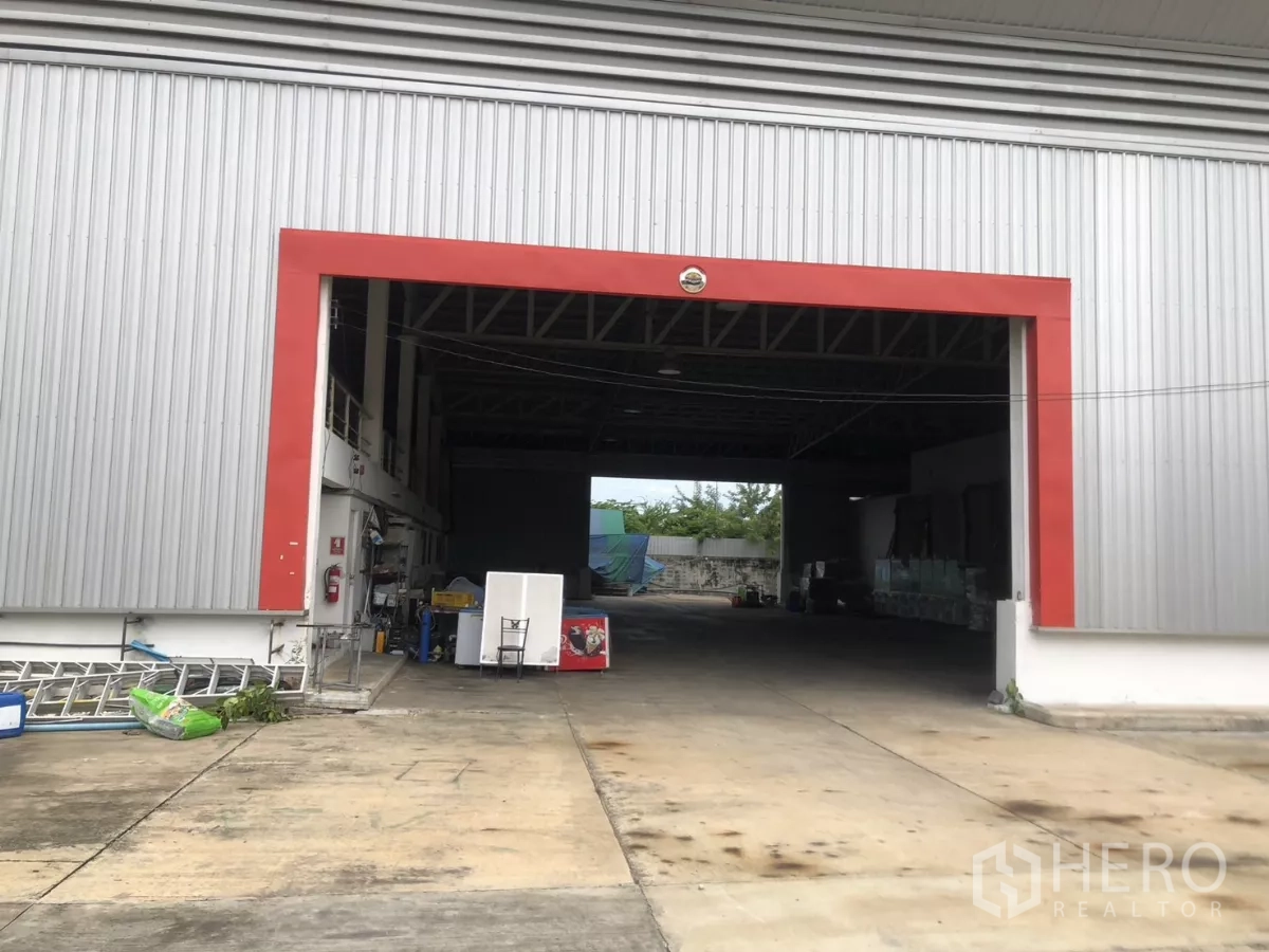 Factory for rent in Mueang Samut Prakan, Samut Prakan - Large warehouse opening with red trim and concrete loading apron
