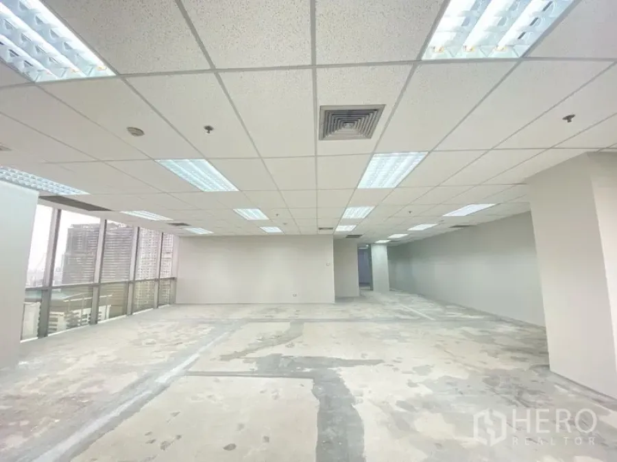 办公空间 出租在Chatuchak, Bangkok - 矩形办公楼层，格栅天花、荧光灯，与高窗城景。