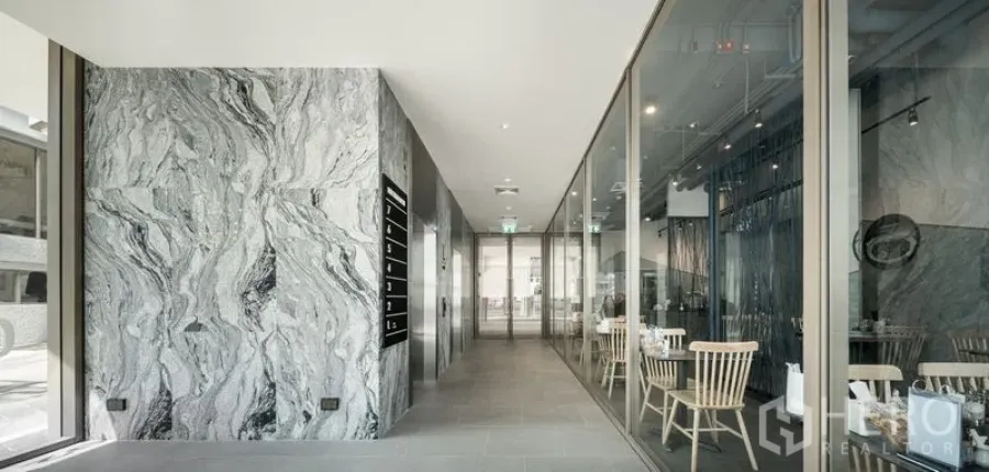 Office Space for rent in Bang Kapi, Bangkok - Modern office lobby corridor with marble wall cladding and glass meeting rooms.