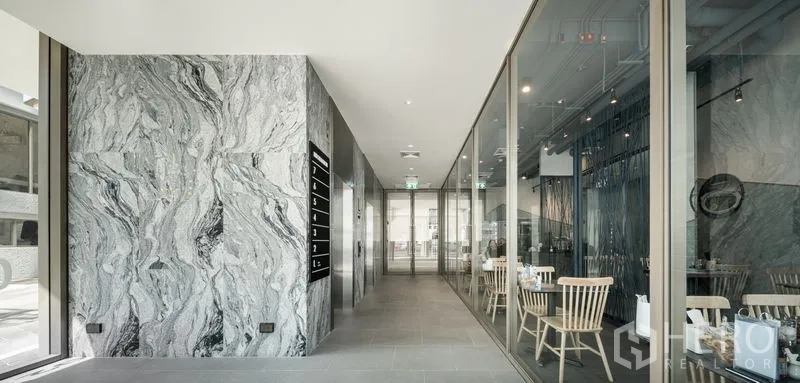 Office Space for rent in Bang Kapi, Bangkok - Modern office lobby corridor with marble wall cladding and glass meeting rooms.