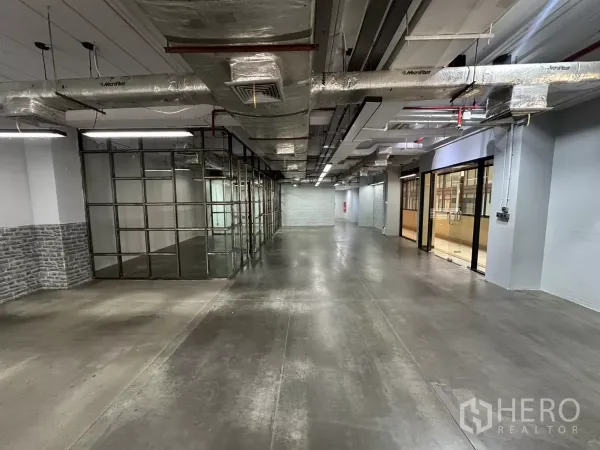 办公空间 出租 - 开放式工业风办公室，水泥地面、玻璃会议室与外露风管。