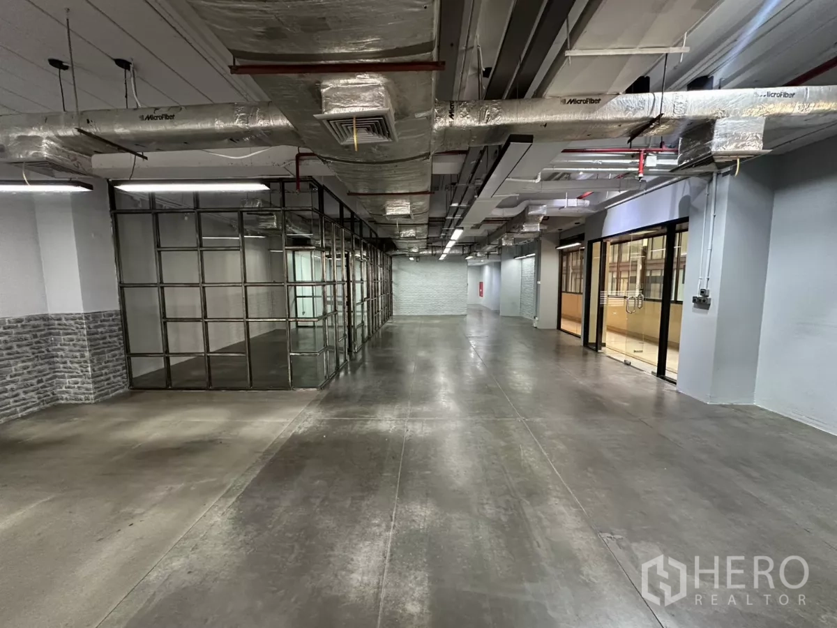 办公空间 出租 - 开放式工业风办公室，水泥地面、玻璃会议室与外露风管。