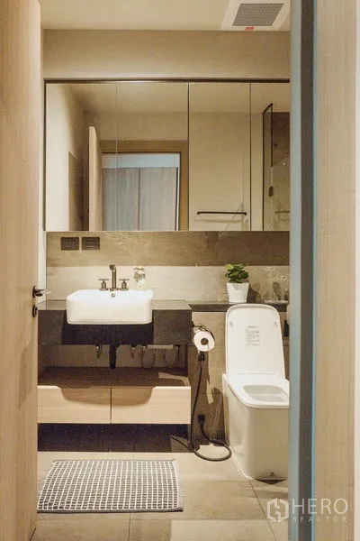 Condominium for rent in Watthana, Bangkok - Compact bathroom with mirror cabinets, square basin, and toilet.