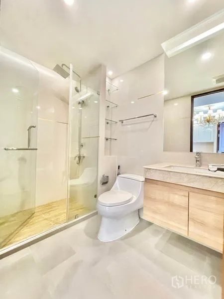 Condominium for sale in Huai Khwang, Bangkok - Second bathroom with walk-in glass shower and vanity unit.