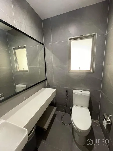 独立式住宅 出售在Bueng Kum, Bangkok - 客卫采用灰色瓷砖，长台面、窗户与坐便器。
