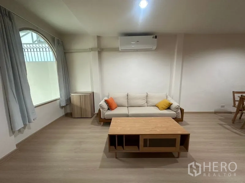 ทาวน์เฮาส์ ให้เช่าหรือขายในPhra Khanong, Bangkok - มุมนั่งเล่นสบายๆ โซฟา หน้าต่างโค้ง และเครื่องปรับอากาศ