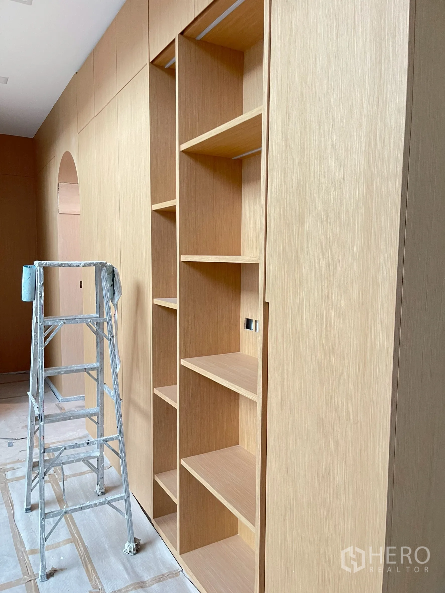 Detached House for sale in Bang Phli, Samut Prakan - Custom light-wood built-in shelving being installed along a feature wall.