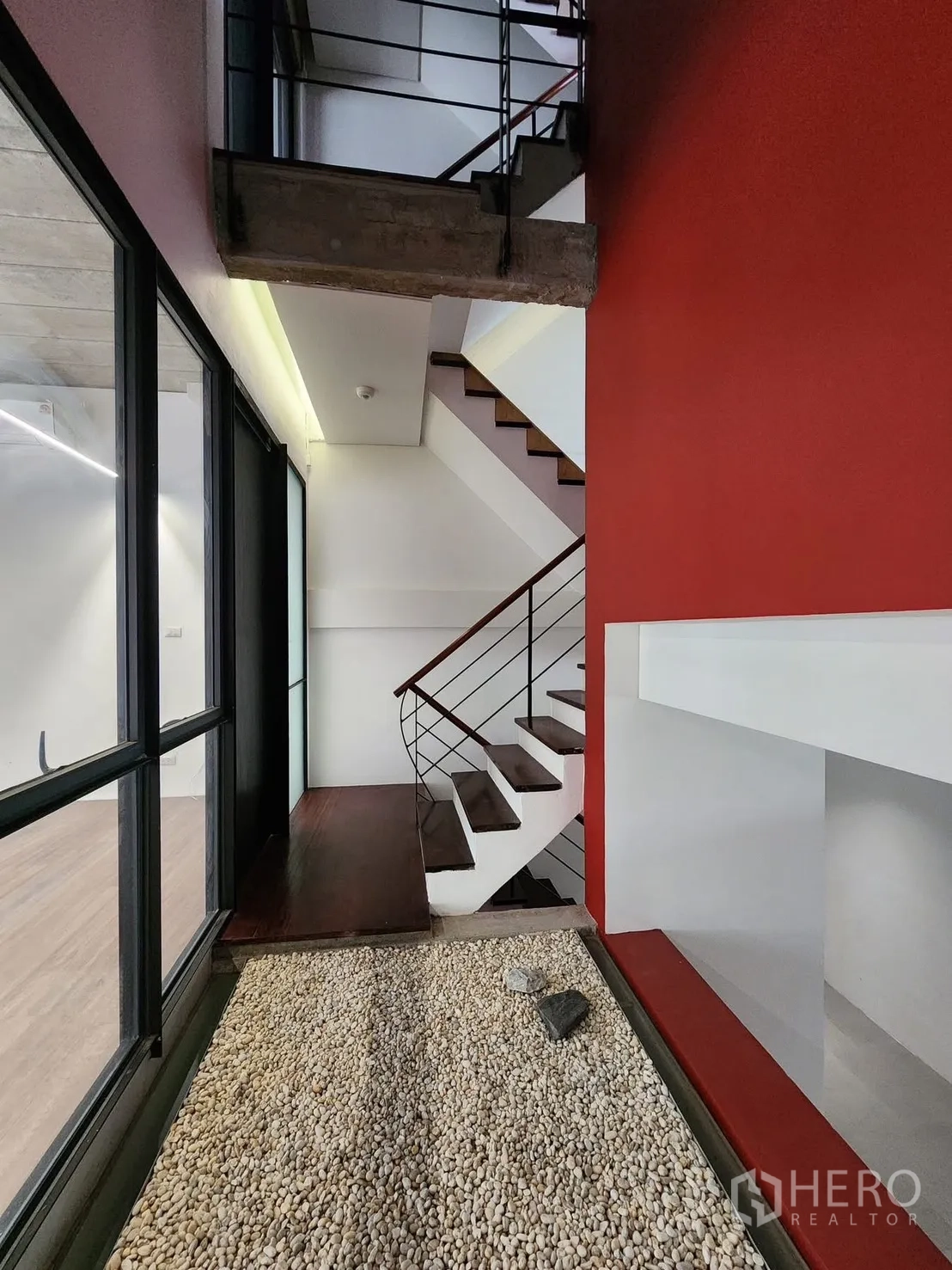 家庭办公室 for rent in Chatuchak, Bangkok - 走廊设室内卵石景观，旁有楼梯与红色墙面。