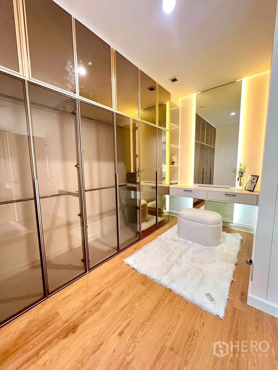 Detached House for rent in Bang Phli, Samut Prakan - Walk-in closet featuring mirrored wardrobes, a vanity, and warm lighting.