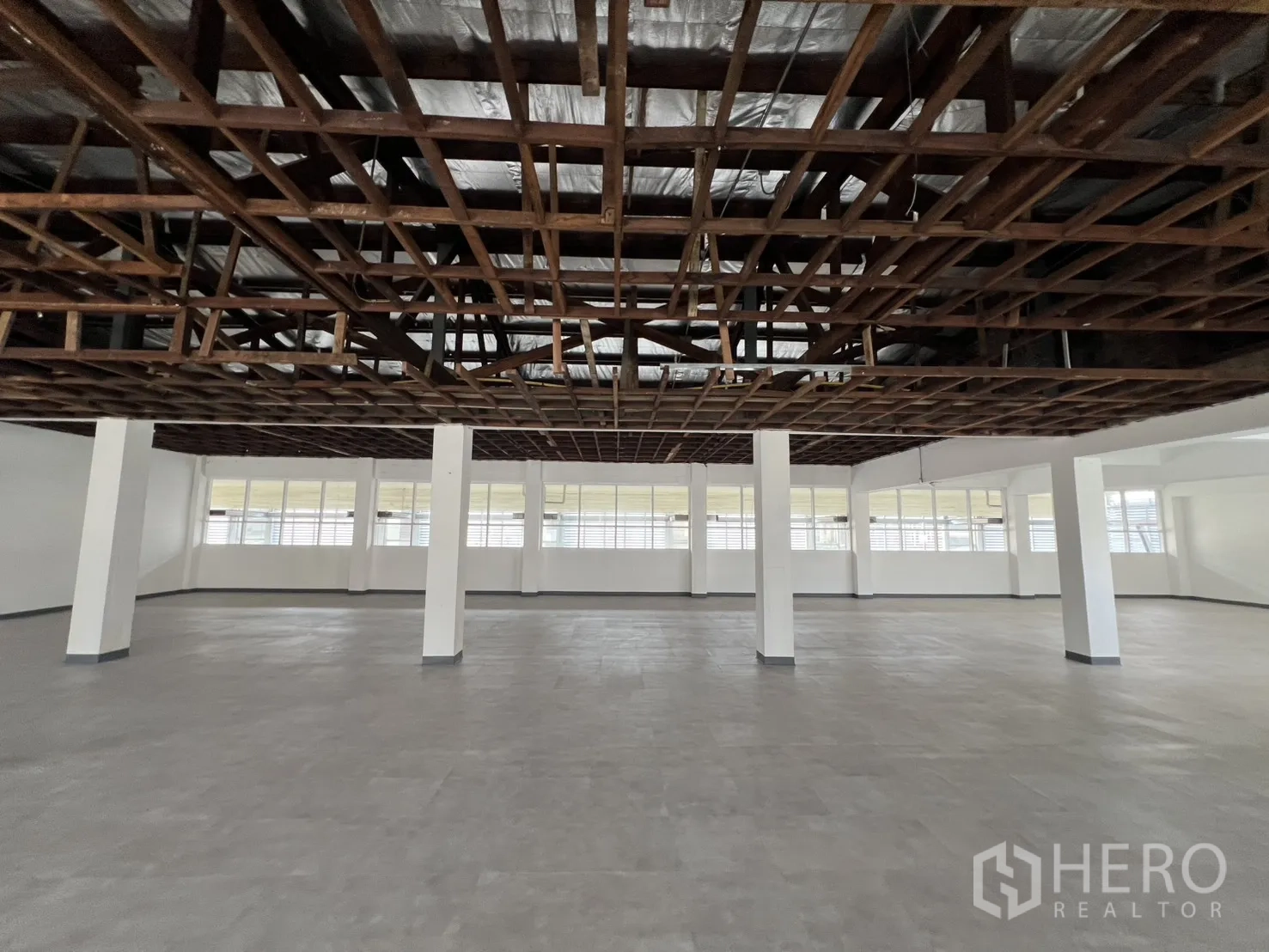 Office Space for rent in Watthana, Bangkok - Open workspace with gray flooring, insulation above the ceiling grid and natural light.