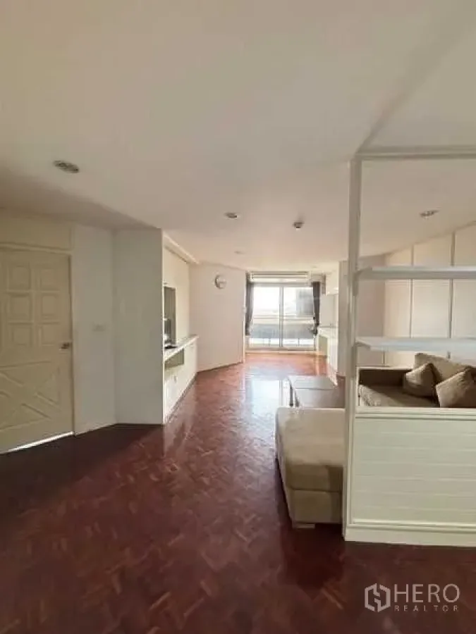 Condominium for rent - Bright living room with parquet floors, built-in TV wall and balcony in a Bangkok condo near BTS Ekkamai.