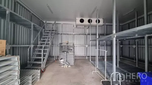Warehouse for rent in Phra Samut Chedi, Samut Prakan - Cold storage interior showing steel racks, metal staircase and industrial cooling unit.