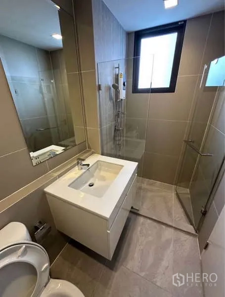 联排别墅 出租在Lat Phrao, Bangkok - 现代浴室，配玻璃淋浴房、大镜子与窗户。