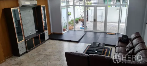 Home Office for rent - Spacious ground‑floor living area with floor‑to‑ceiling windows opening to a private patio