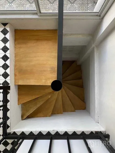 店屋 出售在Suan Luang, Bangkok - 从上方俯视的木质旋转楼梯，中央黑色扶杆。