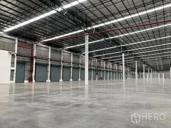 工厂 出租在Wang Noi, Phra Nakhon Si Ayutthaya - 高挑仓厂内部，抛光混凝土地坪、成排立柱与消防喷淋管线