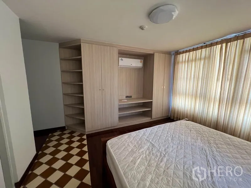 公寓 出租或出售在Watthana, Bangkok - 卧室带嵌入式衣柜与搁架，空调与大窗帘。