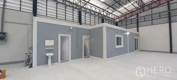 货栈 出租或出售在Khlong Luang, Pathum Thani - 仓库内部，高挑钢结构，内置灰色办公室、卫生间、窗户与抛光混凝土地面。