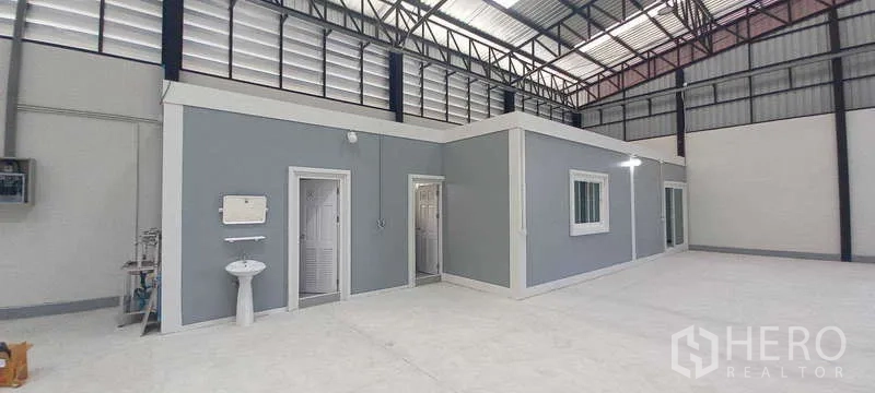 货栈 出租或出售在Khlong Luang, Pathum Thani - 仓库内部，高挑钢结构，内置灰色办公室、卫生间、窗户与抛光混凝土地面。