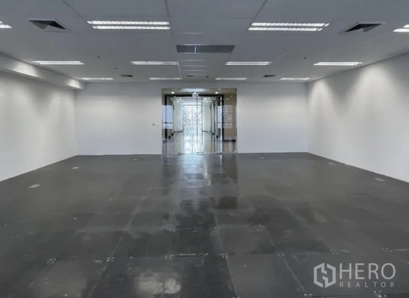 Office Space for rent - Open-plan unfurnished office with raised access flooring, grid ceiling lights, and a glass entryway.