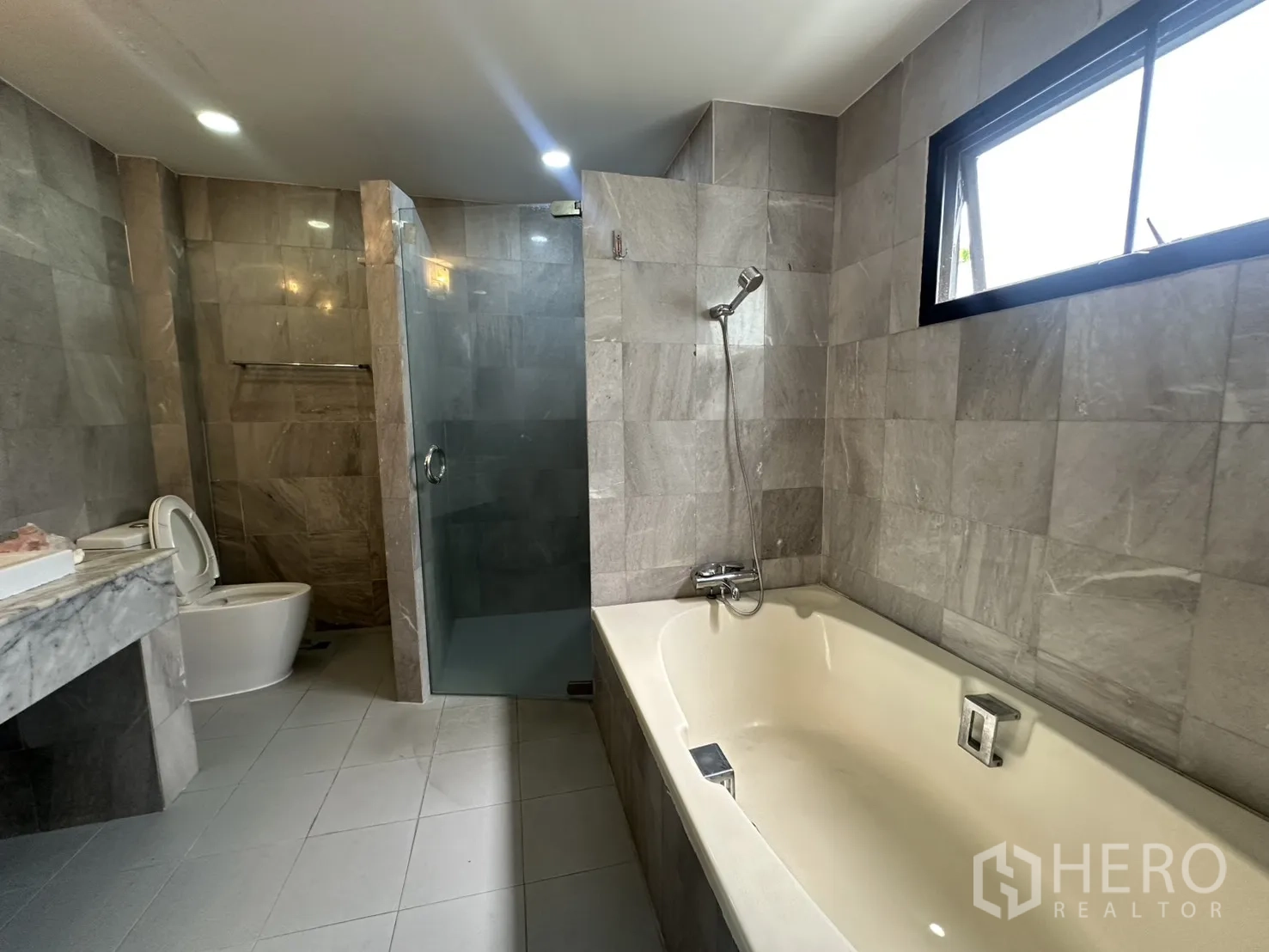 独栋房屋 for rent in Watthana, Bangkok - 采光良好的浴室，窗旁浴缸与独立淋浴