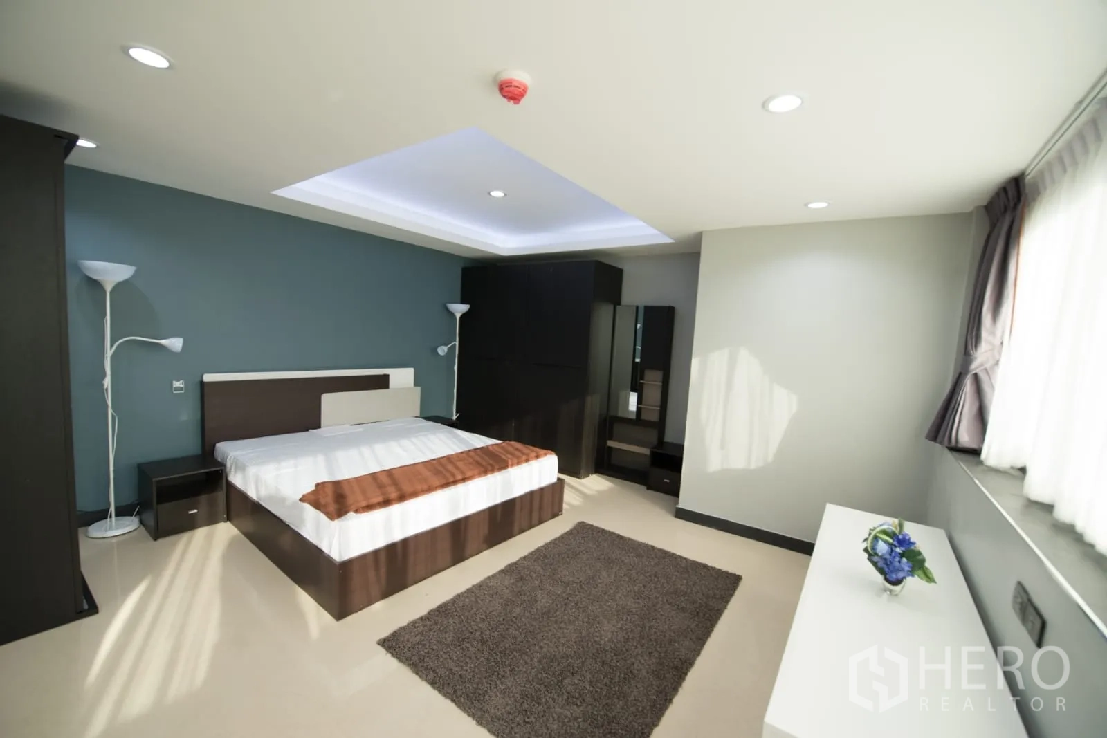 คอนโด ให้เช่าหรือขายในKhlong Toei, Bangkok - อีกมุมของห้องนอนหลัก แสดงหน้าต่างใหญ่ พื้นที่พรม และโต๊ะเครื่องแป้งพร้อมชั้นเก็บของ