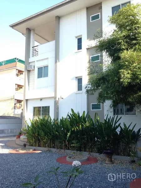 独立式住宅 出售在Phra Khanong, Bangkok - 帕卡侬区现代多层白色独栋别墅，前院绿化与碎石庭院。