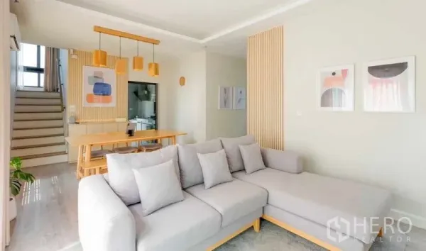 Detached House for rent in Bang Khun Thian, Bangkok - Bright open-plan living and dining area with gray sectional sofa, wooden table and pendant lights.