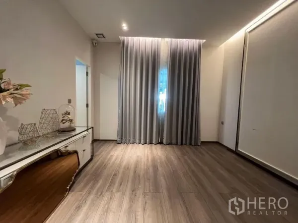 บ้าน ขาย - ห้องอเนกประสงค์พื้นไม้ ผ้าม่านสูง และตู้วางของด้านข้าง