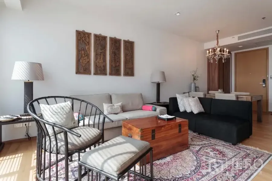 คอนโด ให้เช่าในWatthana, Bangkok - ห้องนั่งเล่นสว่าง โปร่งโซฟา ชุดรับแขก โต๊ะกลางหีบไม้ และงานผนังบนพรมลายสวย