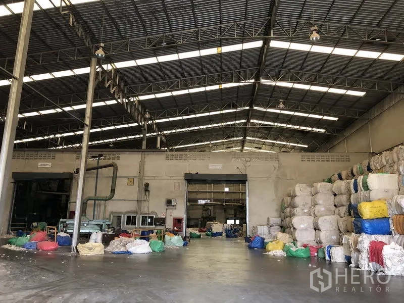 工厂 出租在Bang Bua Thong, Nonthaburi - 工业大厅，混凝土地面与消防设备，物料堆放有序。
