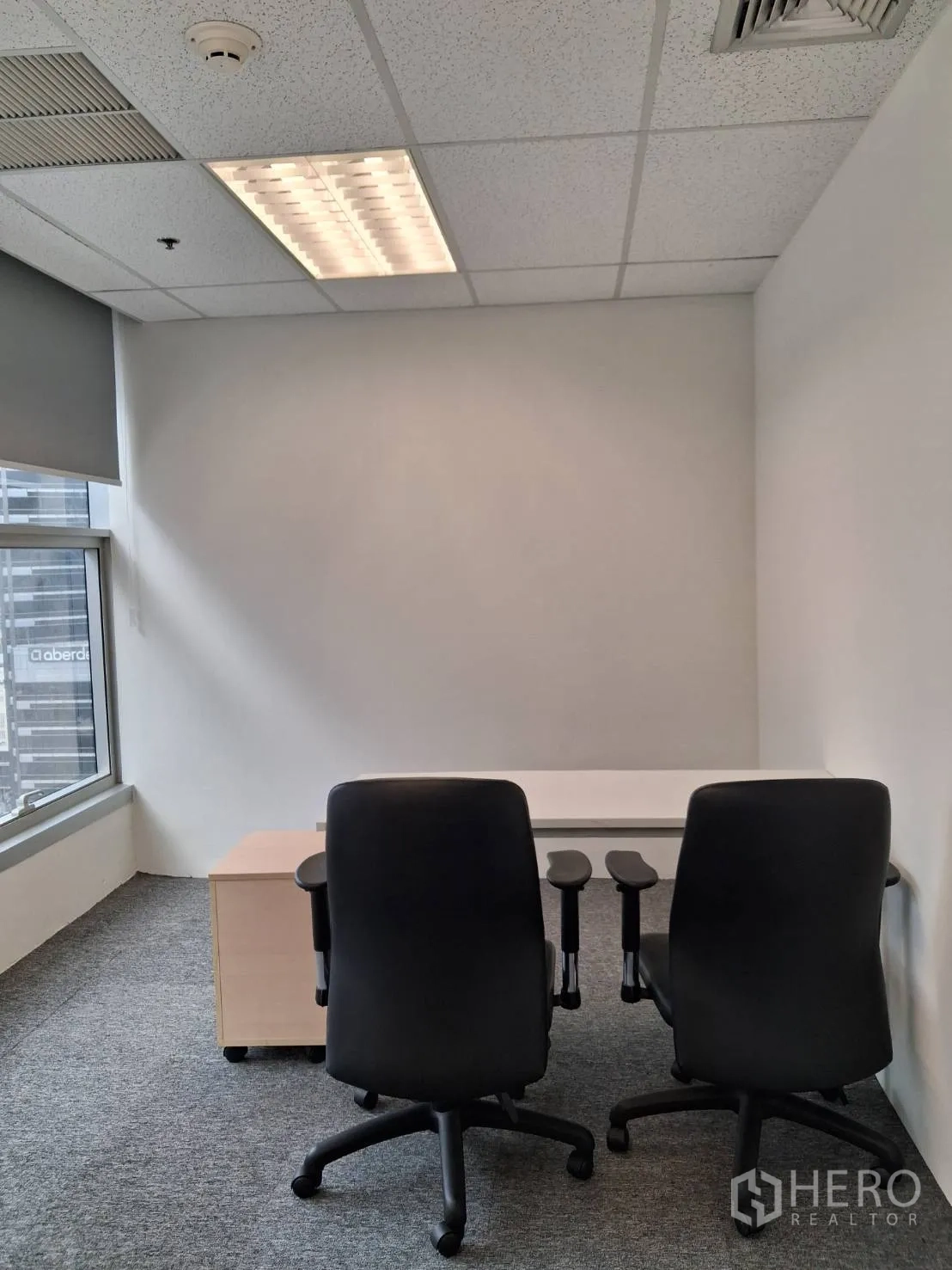 Office Space for rent in Sathon, Bangkok - Compact private office with two chairs, desk and large window with roller blind.