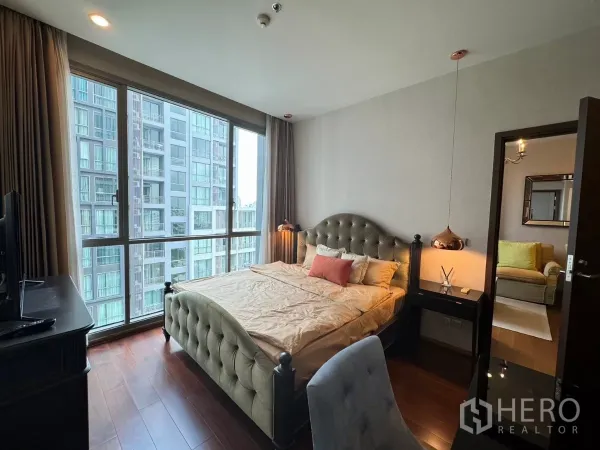 คอนโด ให้เช่าในWatthana, Bangkok - ห้องนอนสว่าง เตียงบุนวม โคมไฟแขวน และหน้าต่างบานใหญ่รับวิวอาคารรอบข้าง